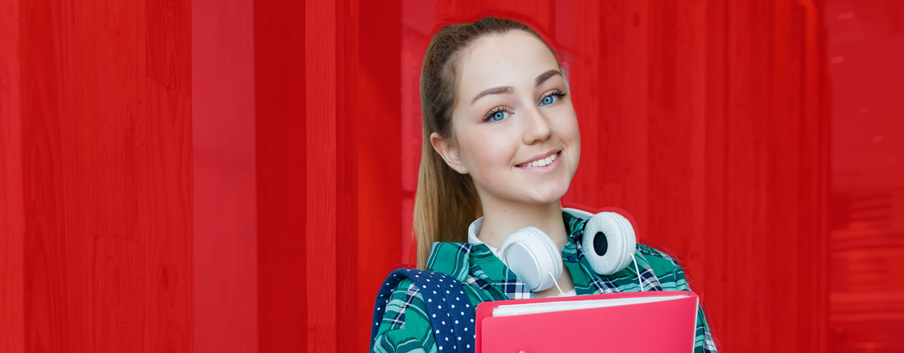 young person smiling holding books.
